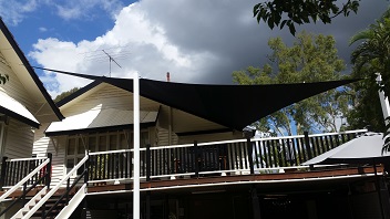 A black custom made shade sail covering a customers deck at their home in Brisbane