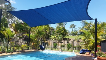 A blue shade custom made shade sail covering a swimming pool at a clients home in Brisbane CBD